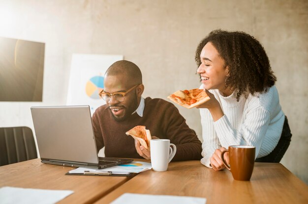 picture showing people eating pizza at the office as new year resolution